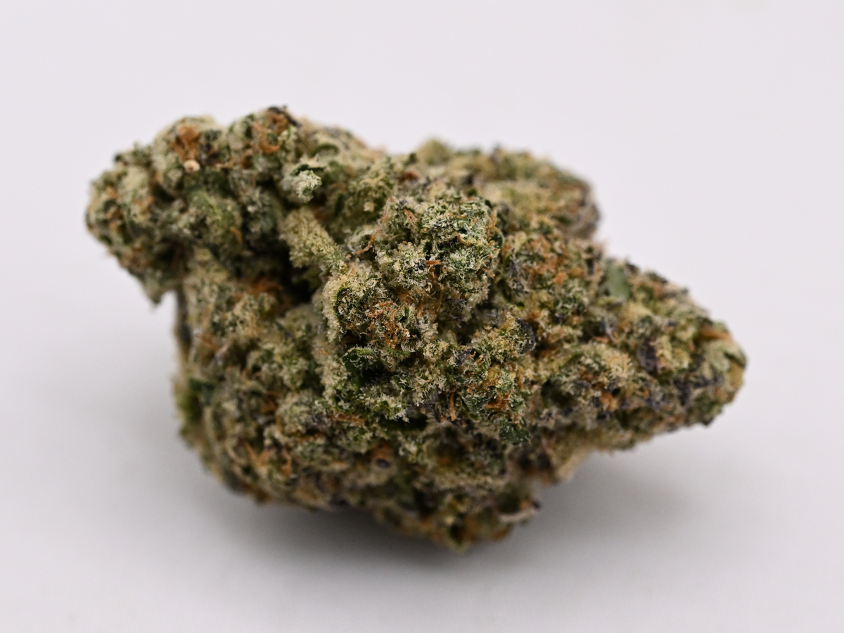 Giraffe Pussy Hybrid THCa flower with frosty green buds, orange pistils, and dense trichome coverage | August Cannabis Club